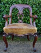 A Victorian C.1850 carved mahogany desk chair in studded leather upholstered seat raised on cabriole