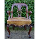 A Victorian C.1850 carved mahogany desk chair in studded leather upholstered seat raised on cabriole