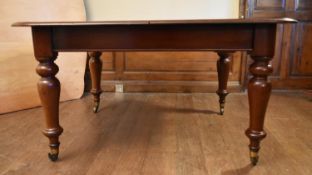 A Victorian mahogany extending dining table with two extra leaves on baluster turned supports