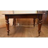 A Victorian mahogany extending dining table with two extra leaves on baluster turned supports