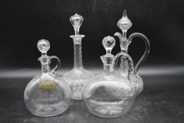 A collection of four Georgian glass decanters, three with handles and one with a foliate etched