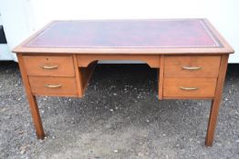 A mid century teak pedestal desk with inset leather top.