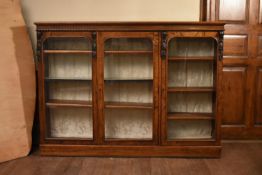 A Victorian C.1850 burr walnut dwarf bookcase with three arched glazed doors enclosing shelves