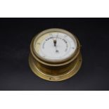 A 19th century brass rivet style Aneroid Barometer with a white enamel dial. H.24 W.24 D.12cm