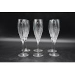 A set of six Christofle Iriana crystal champagne flutes with engraved sunburst pattern. Signed to