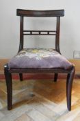 A Regency mahogany dining chair with tapestry upholstered drop in seat on sabre supports. H.70 W.