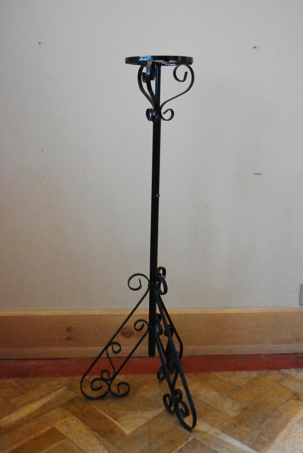 A wrought iron lamp stand on scrolling tripod base. H.105 Dia.18cm