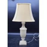 A carved alabaster urn design table lamp with cream shade. H.39 (H.56cm with shade) W.34cm