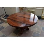 A 19th century Continental flame mahogany circular tilt top table on facetted baluster platform