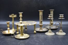A collection of early 20th century brassware. Including three adjustable chamberstick, two pairs