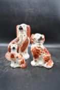 A collection of three 19th century tan and white Staffordshire spaniels. Largest H.26 W.19cm (3)