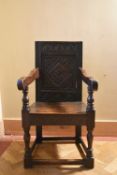 An 18th century oak Wainscott chair with carved lozenge panelled back and solid seat on turned
