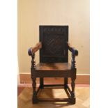 An 18th century oak Wainscott chair with carved lozenge panelled back and solid seat on turned