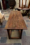 An 18th century country oak planked top refectory table with cleated ends resting on square