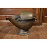 A Victorian helmet shaped brass coal skuttle with shovel. H.40 W.47cm (2)