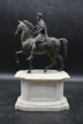 A Bronze equestrian statue of Marcus Aurelius, standing on a white marble base. H.36 W.20 D.13cm