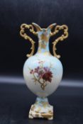A 19th century twin handled urn vase with gilded detailing and handpainted floral and bird design.