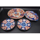 Four late 18th century Japanese Imari plates with hand painted floral decoration and scalloped rims.