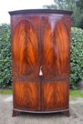 A Georgian style flame mahogany bow fronted wardrobe on swept bracket feet. H.190 W.112 D.51cm