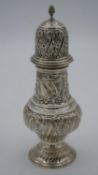 A large Victorian silver repousse sugar sifter with stylised floral and foliate design and shield