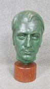 A mid century patinated bronze sculpture of a male head mounted on a polished teak base.