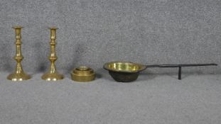 A pair of brass candlesticks, a set of weights and an antique brass and iron skillet.