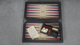 A vintage backgammon board with leather effect interior, pieces, die and instruction booklet. 50x43