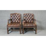 A pair of mahogany framed Gainsborough style library armchairs in deep buttoned leather upholstery.