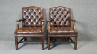 A pair of mahogany framed Gainsborough style library armchairs in deep buttoned leather upholstery.