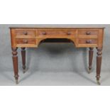 A late Georgian mahogany writing table with an arrangement of five drawers on tapering reeded