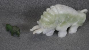 A large carved Chinese jade bull sculpture with engraved floral motifs along with a carved green
