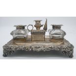 A Georgian silver desk stand with two silver foliate design glass inkwells and silver chamber