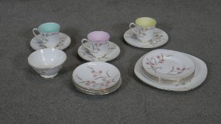 A part Royal Tuscan tea set with stylised floral design and coloured insides to the three cups.
