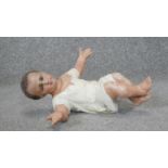 A 1900's French painted carved wooden statue of a lying baby Jesus. Makers stamp to the back. L.26cm