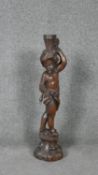 A carved candlestick in the form of a cherub on a Rococo socle.