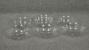 Six cut glass bowls with star cut bases and flared rims.