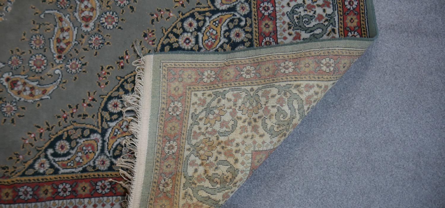 A Persian style woollen carpet with floral central medallion within foliate multiple borders. - Image 3 of 4