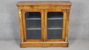 A Victorian burr walnut two door display cabinet with ormolu mounts and satinwood Arabesque inlay on