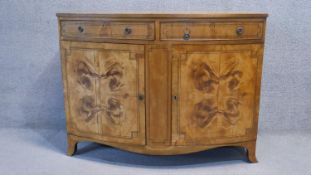 A 19th century satinwood bow fronted side cabinet with central inlaid and crossbanded top and