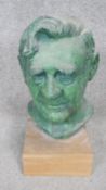 A patinated bronze effect ceramic head of a gentleman mounted on a wooden base. H.38cm