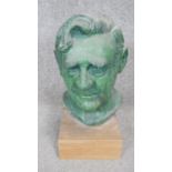 A patinated bronze effect ceramic head of a gentleman mounted on a wooden base. H.38cm