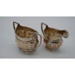 A silver sugar bowl and matching milk jug, with rope design edge and ball feet. Hallmarked: E&Dco