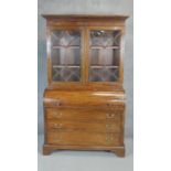 A 19th century mahogany and ebony strung cylinder bureau bookcase with fitted interior on bracket