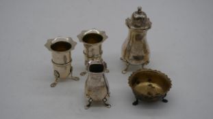 A collection of silver salts and a pepper shaker. Various British hallmarks. Three with lion paw