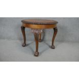 A Georgian style burr walnut quarter veneered coffee table on carved cabriole supports. H.51 Dia.