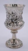 An early Victorian silver repousse stemmed goblet with a scrolling floral and foliate design.