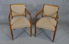 A pair of contemporary late Georgian style armchairs on reeded tapering supports.