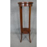 An Edwardian mahogany and satinwood inlaid jardiniere stand on swept supports united by undertier.