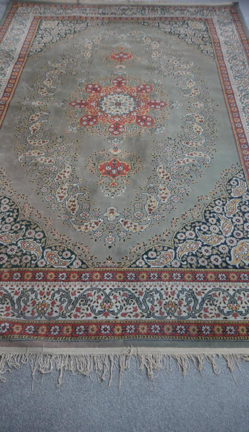 A Persian style woollen carpet with floral central medallion within foliate multiple borders. - Image 2 of 4