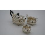 A three piece Edwardian silver tea set by Walker and Hall with ebony handles. With crenellated